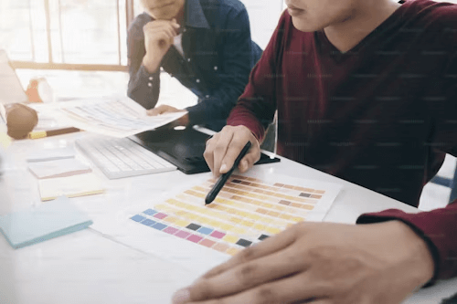 Designers working with a color palette for a logo redesign project, reviewing brand identity options and selecting a new logo color scheme for effective rebranding.