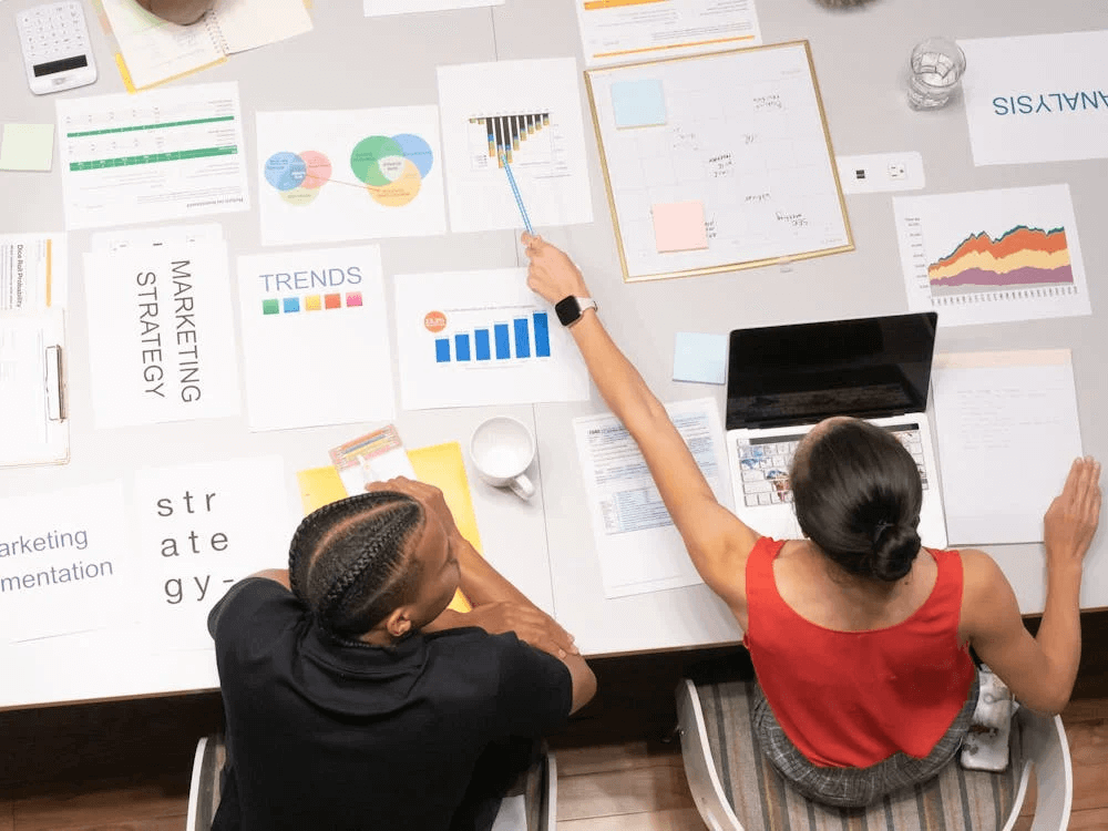 Team conducting user research in a workspace, crucial for understanding user needs and behaviors to inform user experience design and improve the overall design process.